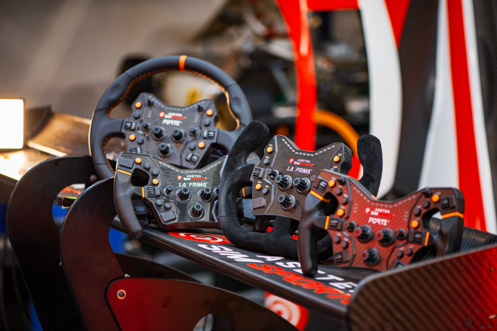 Auswahl verschiedener Simracing-Lenkräder in einem Racing-Cockpit